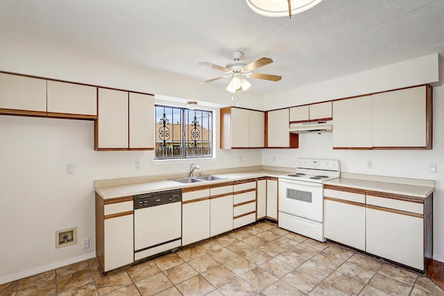 kitchen featuring white appliances, light countertops, under cabinet range hood, and a sink