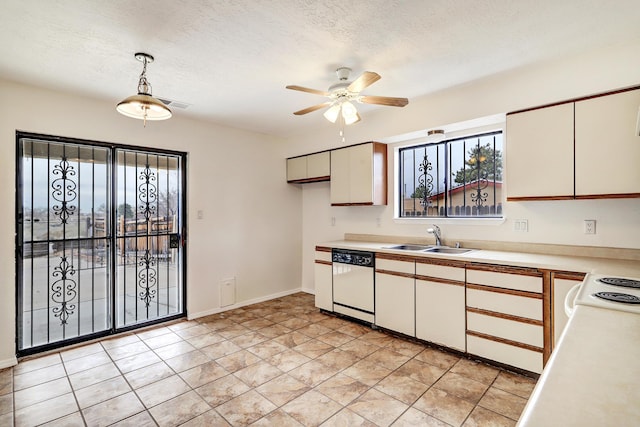 kitchen with a textured ceiling, white appliances, light countertops, and a sink