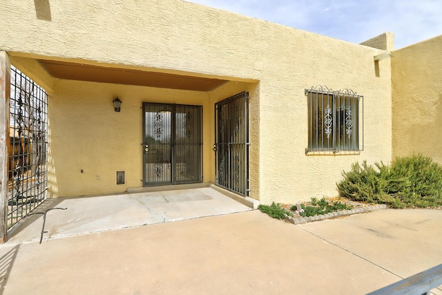 doorway to property with stucco siding and a patio