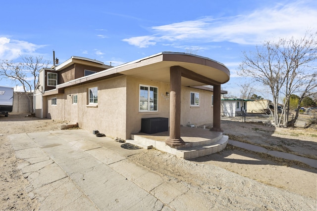 exterior space with a patio area and stucco siding