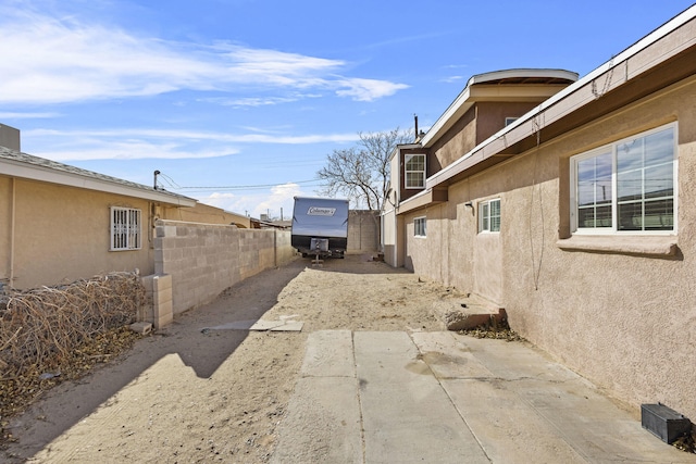 exterior space with stucco siding, a patio area, and fence