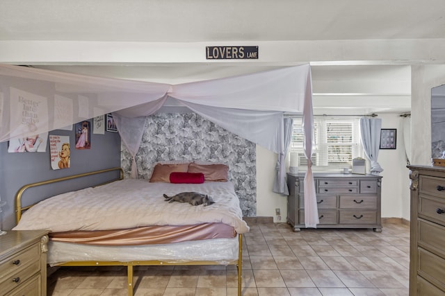 bedroom with light tile patterned floors and baseboards