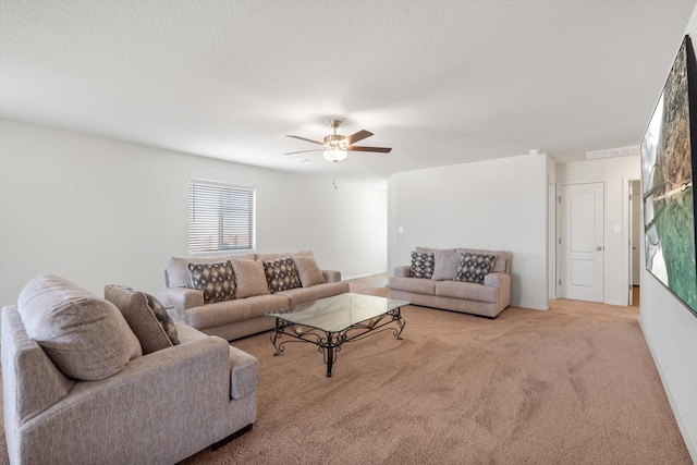 living room featuring visible vents, carpet floors, a textured ceiling, and a ceiling fan