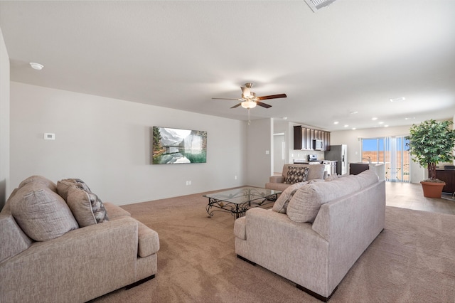 living area featuring recessed lighting, light colored carpet, and ceiling fan