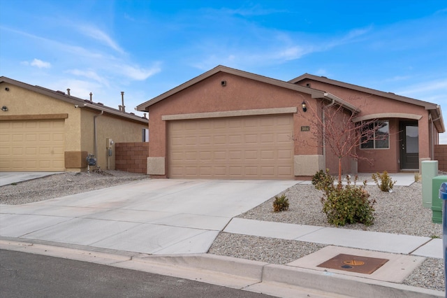 view of front of property featuring stucco siding, concrete driveway, an attached garage, and fence