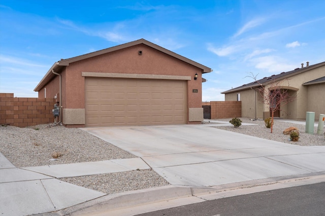 view of front of property featuring concrete driveway, fence, a garage, and stucco siding