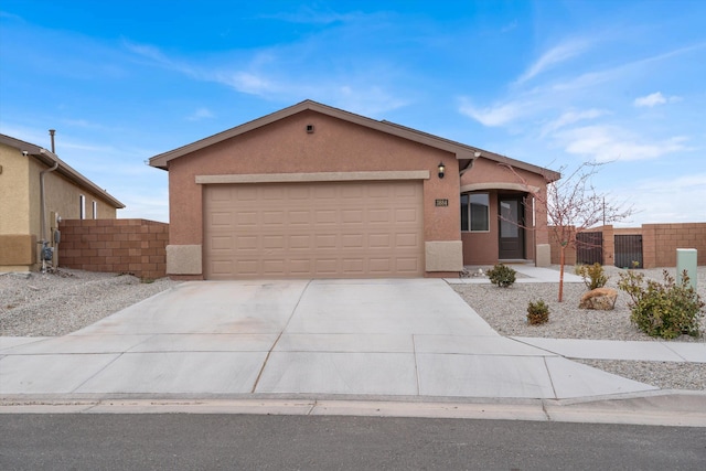 view of front of property featuring stucco siding, a garage, concrete driveway, and fence