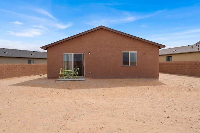 back of house with stucco siding, a patio, and a fenced backyard