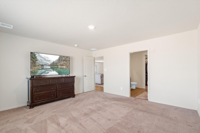 bedroom with visible vents, light carpet, baseboards, and connected bathroom