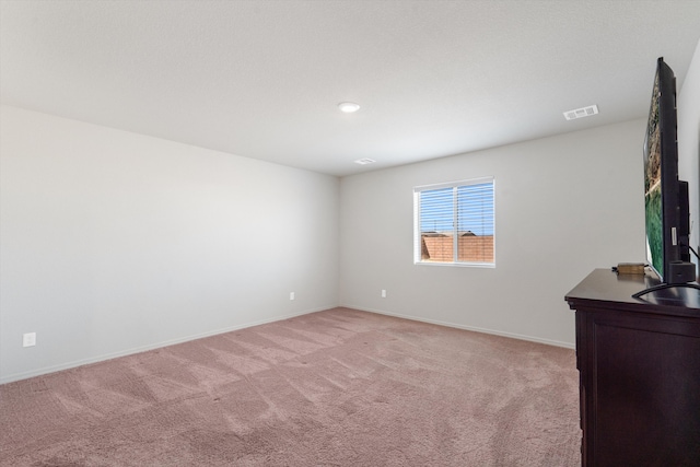 spare room with visible vents, light colored carpet, baseboards, and a sink