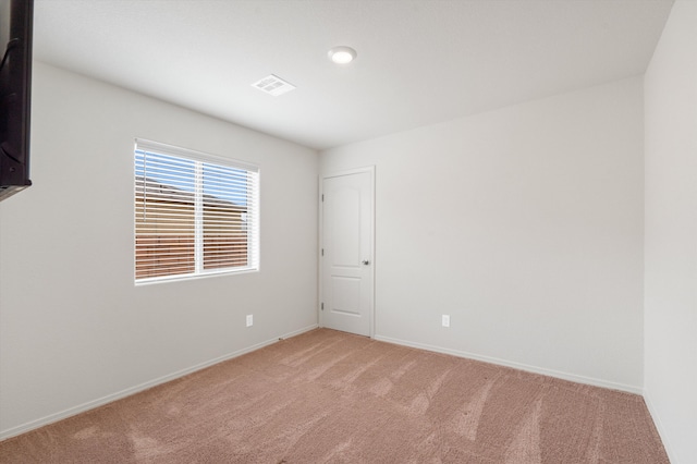 unfurnished room with baseboards and light colored carpet