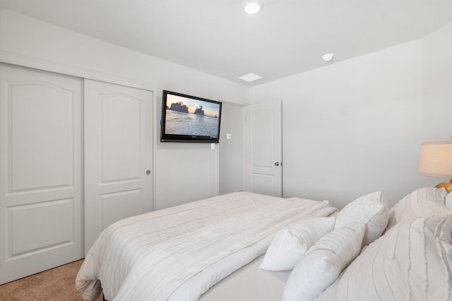 bedroom with light colored carpet and a closet