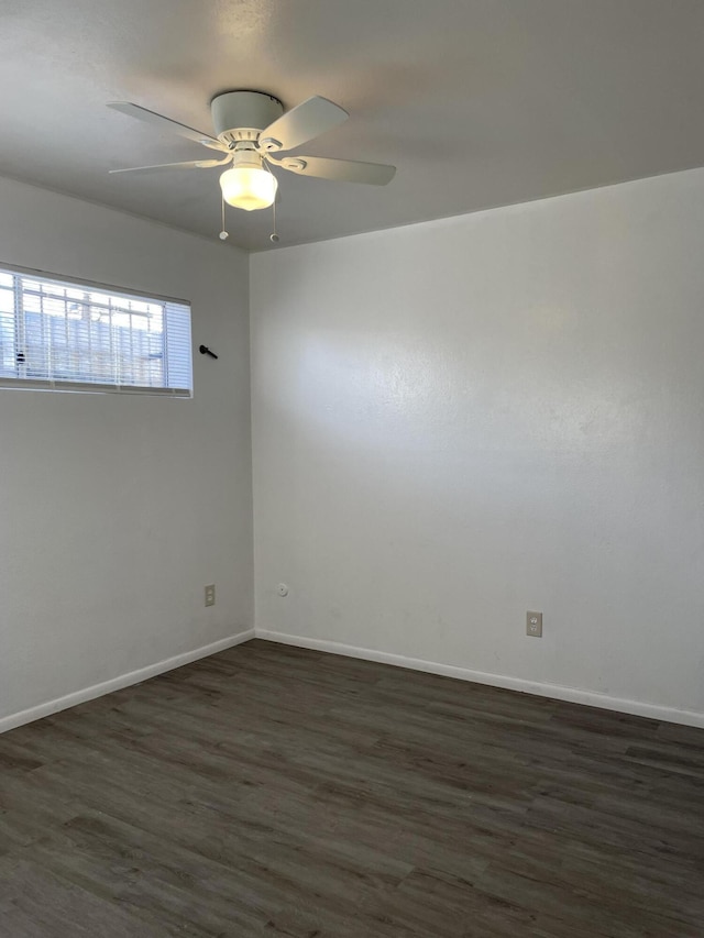 unfurnished room featuring dark wood-style floors, baseboards, and a ceiling fan