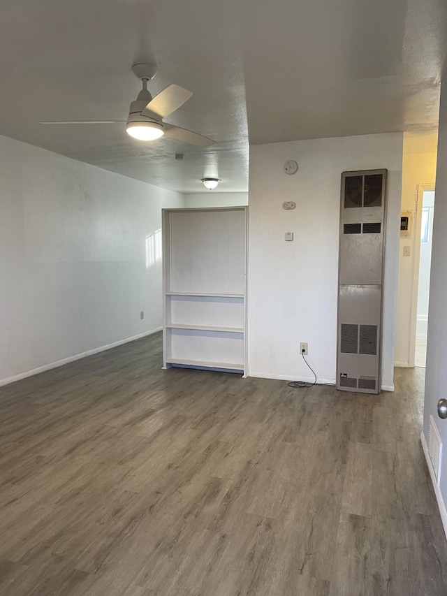 spare room with ceiling fan, baseboards, and wood finished floors