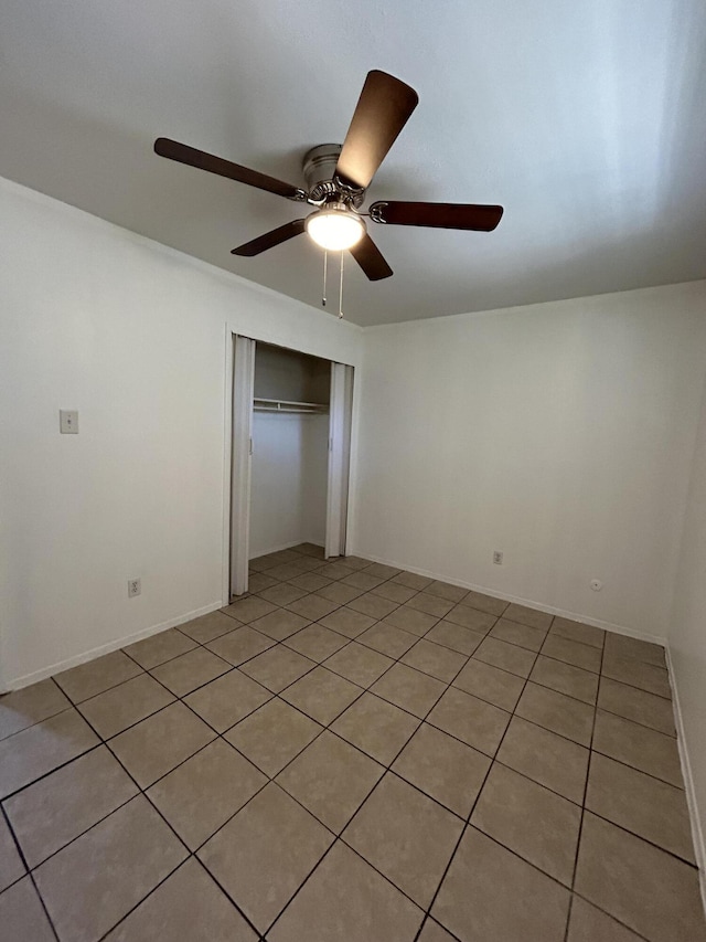 unfurnished bedroom with a ceiling fan and a closet