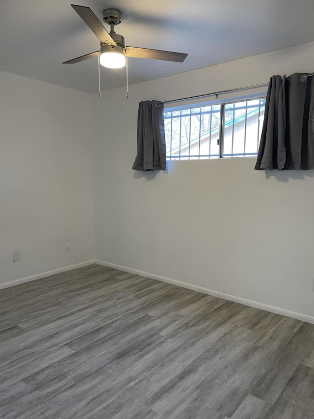 unfurnished room with ceiling fan, baseboards, and wood finished floors