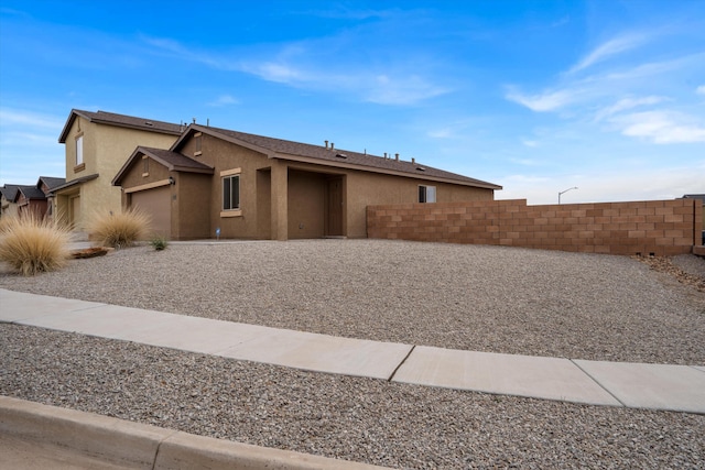 view of front of home featuring fence and stucco siding