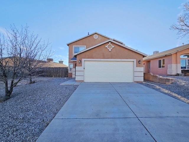 view of front of property featuring fence, a garage, driveway, and stucco siding