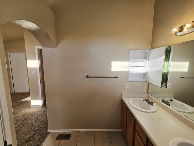 bathroom with double vanity, visible vents, baseboards, and a sink