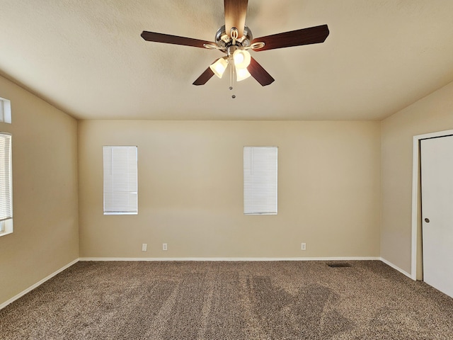 carpeted empty room featuring baseboards, a textured ceiling, and a ceiling fan