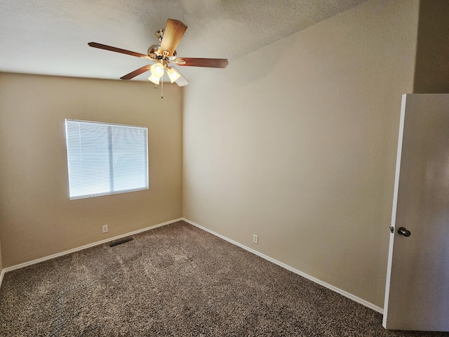 spare room featuring a ceiling fan, baseboards, visible vents, a textured ceiling, and dark carpet