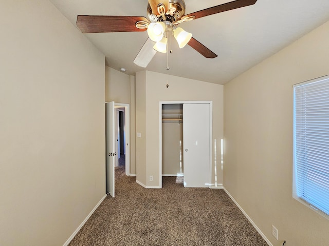 unfurnished bedroom with a closet, lofted ceiling, baseboards, and dark carpet