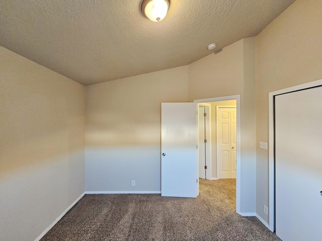 unfurnished bedroom with vaulted ceiling, baseboards, carpet floors, and a textured ceiling