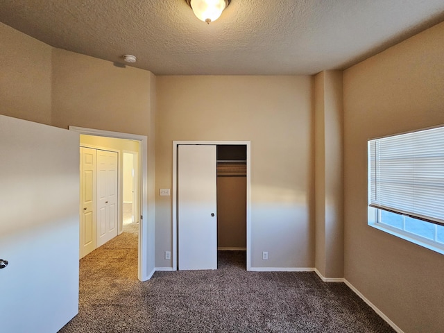 unfurnished bedroom with a closet, baseboards, carpet floors, and a textured ceiling