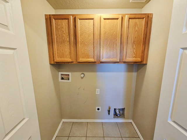 washroom featuring hookup for a gas dryer, cabinet space, light tile patterned floors, hookup for an electric dryer, and hookup for a washing machine