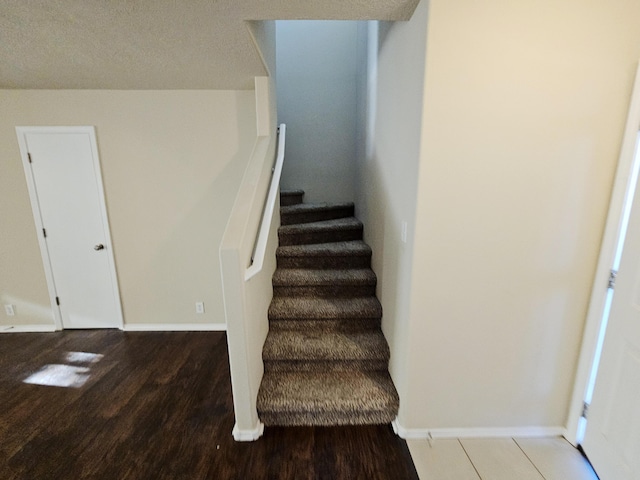 stairs featuring wood finished floors and baseboards