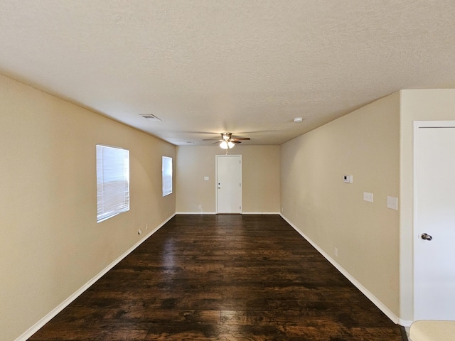 unfurnished room with visible vents, baseboards, ceiling fan, wood finished floors, and a textured ceiling