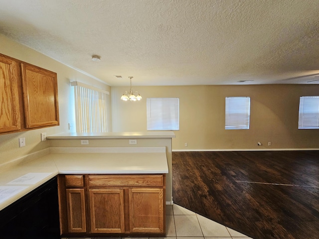 kitchen with a peninsula, brown cabinetry, open floor plan, and light countertops