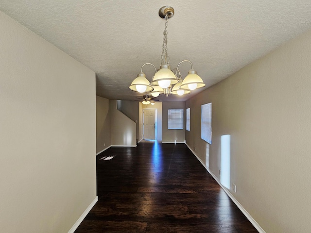 unfurnished dining area with a notable chandelier, wood finished floors, and baseboards