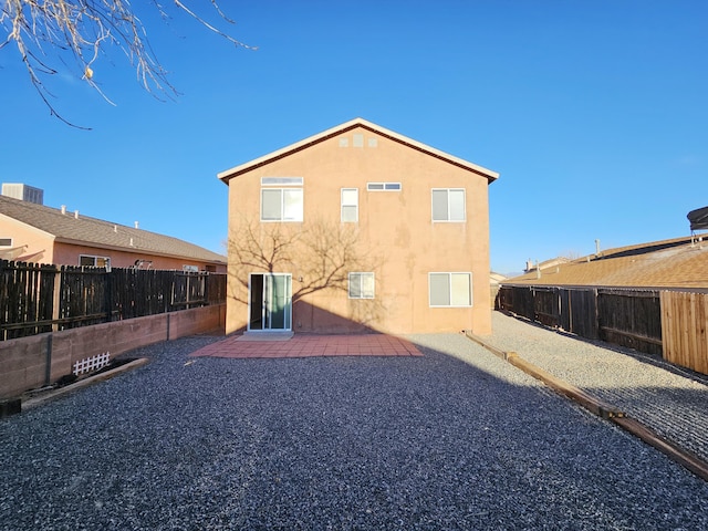 back of property with stucco siding, a fenced backyard, and a patio area