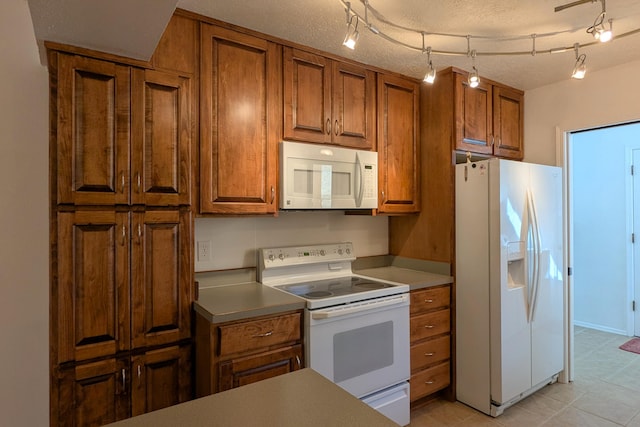 kitchen with brown cabinetry, white appliances, and a textured ceiling