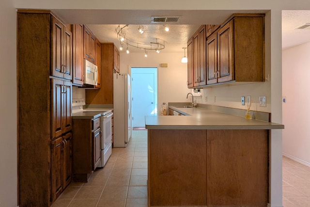 kitchen with visible vents, light tile patterned floors, white appliances, a textured ceiling, and a sink