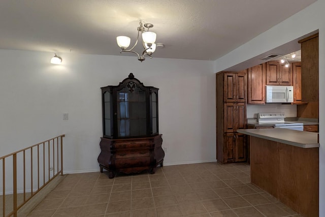 kitchen featuring white appliances, visible vents, baseboards, brown cabinets, and a chandelier