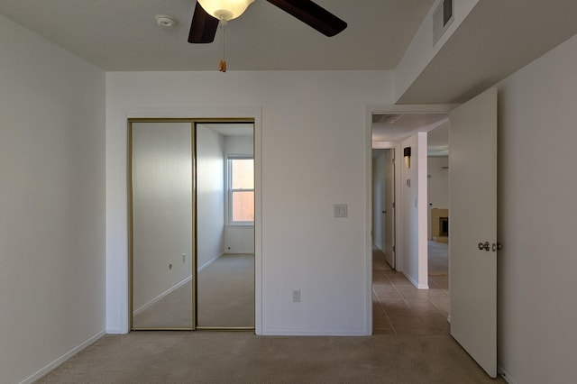 unfurnished bedroom featuring visible vents, a ceiling fan, a closet, carpet floors, and baseboards