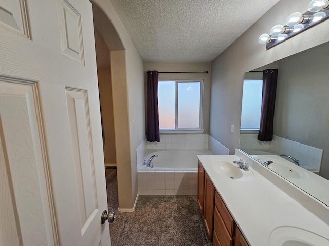 6619 Country Hills Ct NW, Albuquerque, NM 87114 - full bathroom with double vanity, a textured ceiling, a garden tub, and a sink