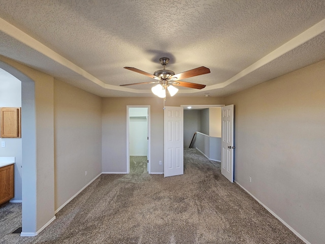 6619 Country Hills Ct NW, Albuquerque, NM 87114 - unfurnished bedroom featuring arched walkways, a spacious closet, baseboards, and carpet