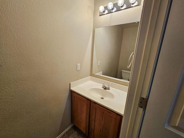 6619 Country Hills Ct NW, Albuquerque, NM 87114 - bathroom featuring toilet, vanity, and a textured wall