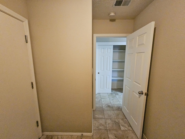 6619 Country Hills Ct NW, Albuquerque, NM 87114 - hallway with visible vents, baseboards, and a textured ceiling