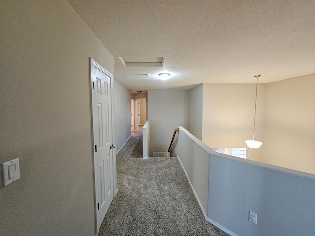 6619 Country Hills Ct NW, Albuquerque, NM 87114 - hallway featuring an upstairs landing, a textured ceiling, carpet flooring, baseboards, and attic access