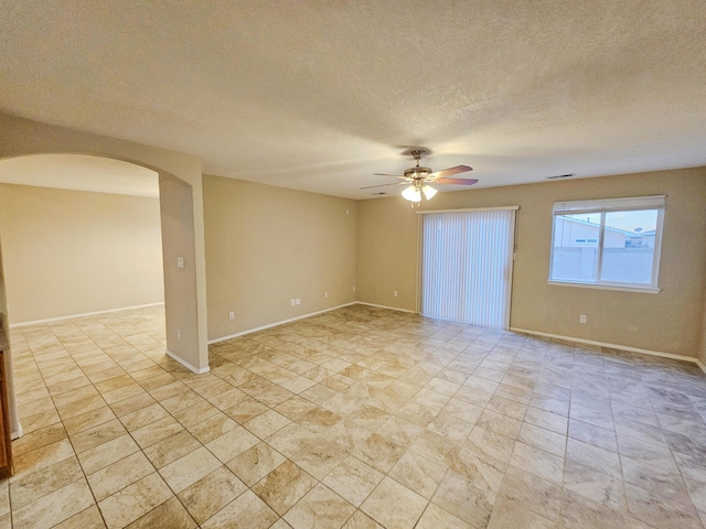 6619 Country Hills Ct NW, Albuquerque, NM 87114 - spare room featuring visible vents, a ceiling fan, a textured ceiling, arched walkways, and baseboards