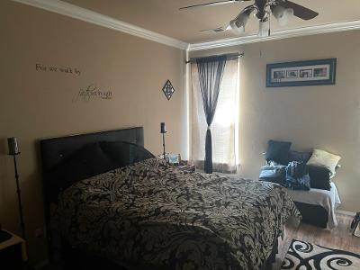 bedroom with crown molding, a ceiling fan, and wood finished floors