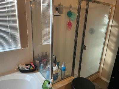 full bathroom with a stall shower and a garden tub