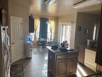 kitchen featuring light tile patterned floors, a kitchen island, refrigerator, dishwasher, and dark countertops