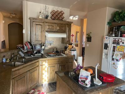 kitchen with a kitchen island, stainless steel gas cooktop, a sink, white refrigerator with ice dispenser, and under cabinet range hood