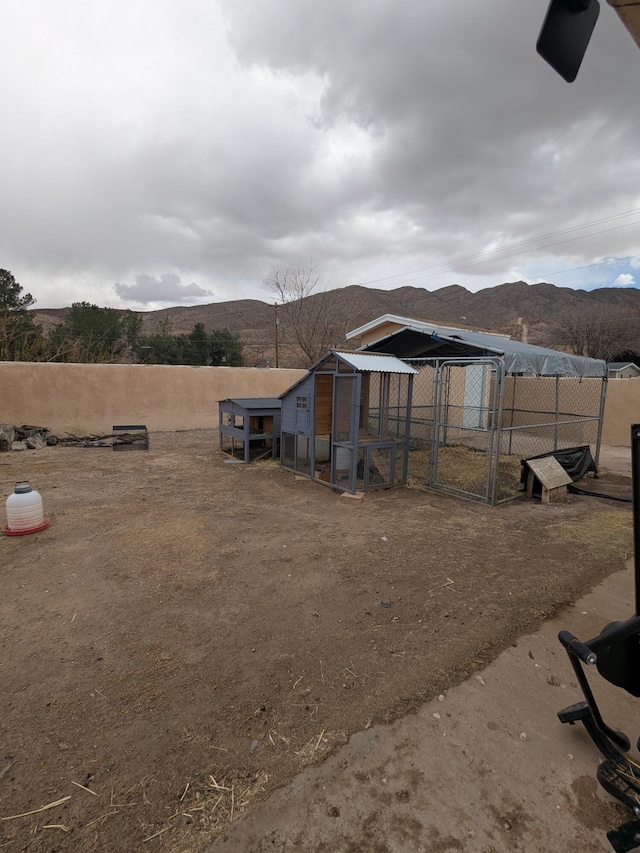 view of yard featuring an outbuilding, a mountain view, and exterior structure