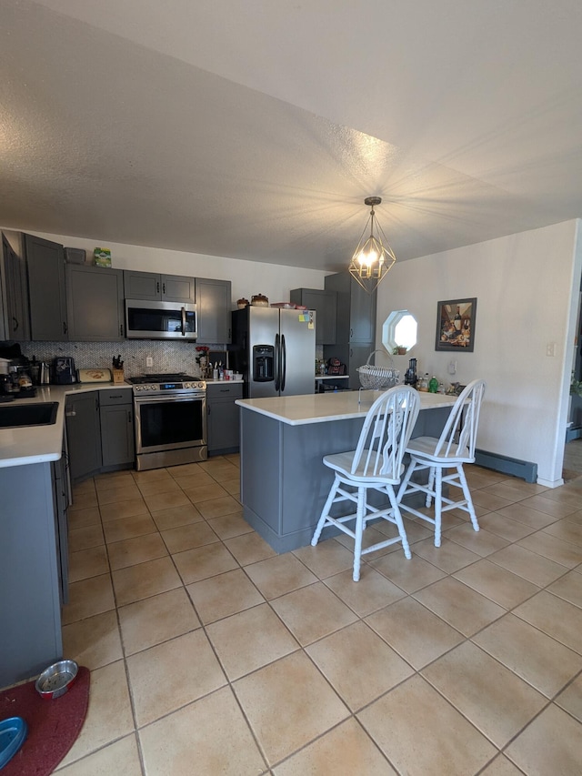 kitchen with light tile patterned floors, stainless steel appliances, backsplash, and light countertops